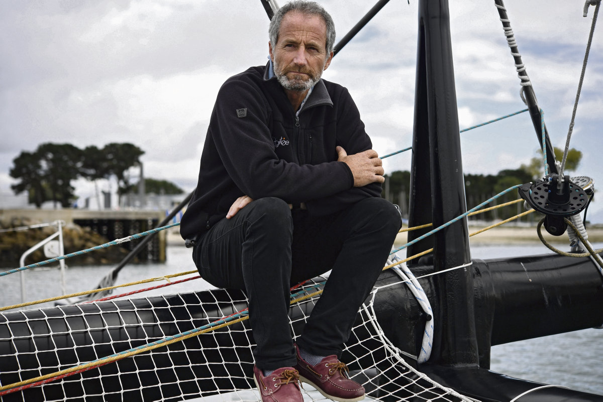 michel desjoyeaux assis sur un voilier