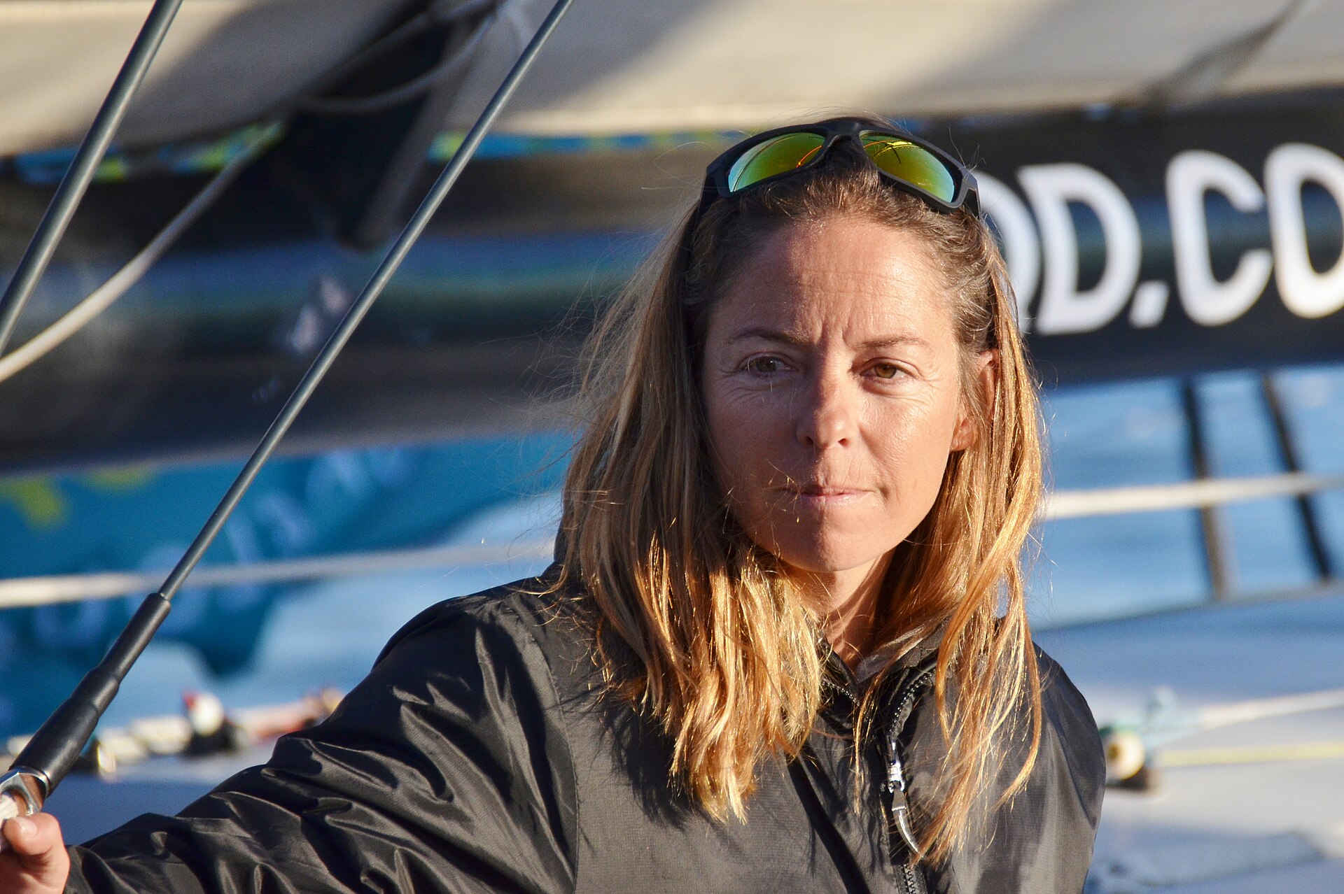 Portrait de la skippeuse Alexia Barrier, lunettes de soleil sur la tête, sur le pont de son Imoca avant la Route du Rhum 2018