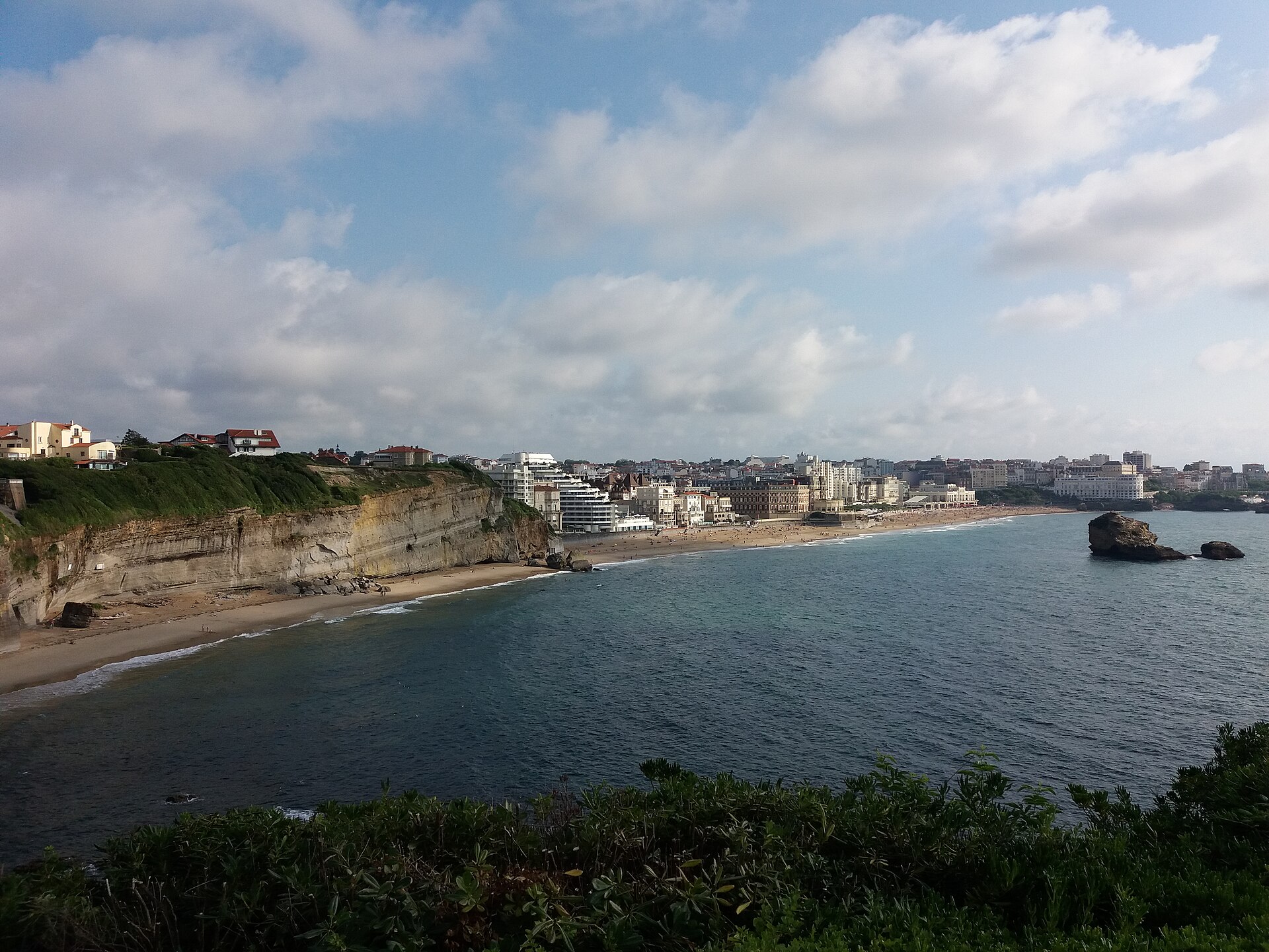 Vue sur la baie de Biarritz, ses falaises, la Grande Plage et la ville sous un ciel nuageux